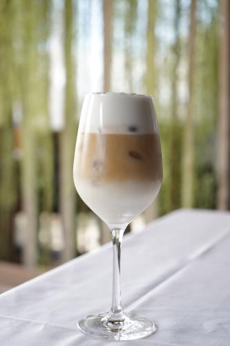 iced latte met drie lagen in groot wijnglas