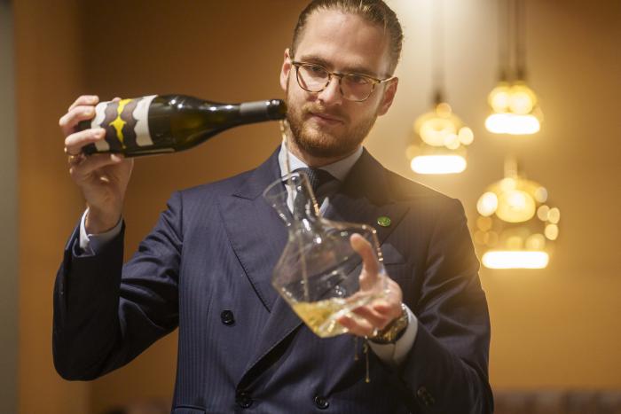 Sommelier karaffeert een fles wijn